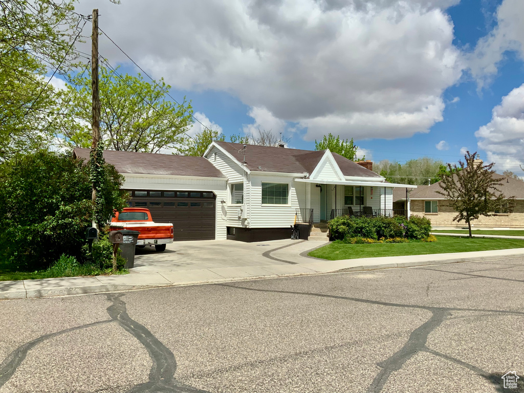 Ranch-style house with an attached garage, driveway, and a porch