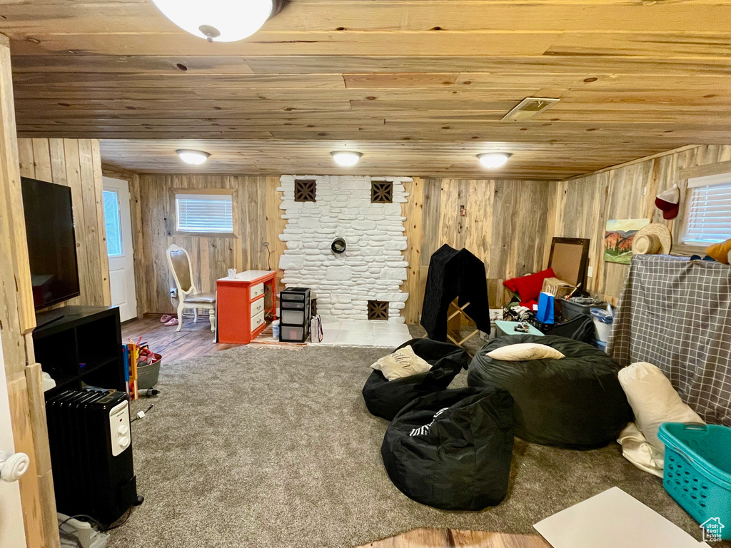 Living room featuring wood ceiling, wooden walls, and wood finished floors