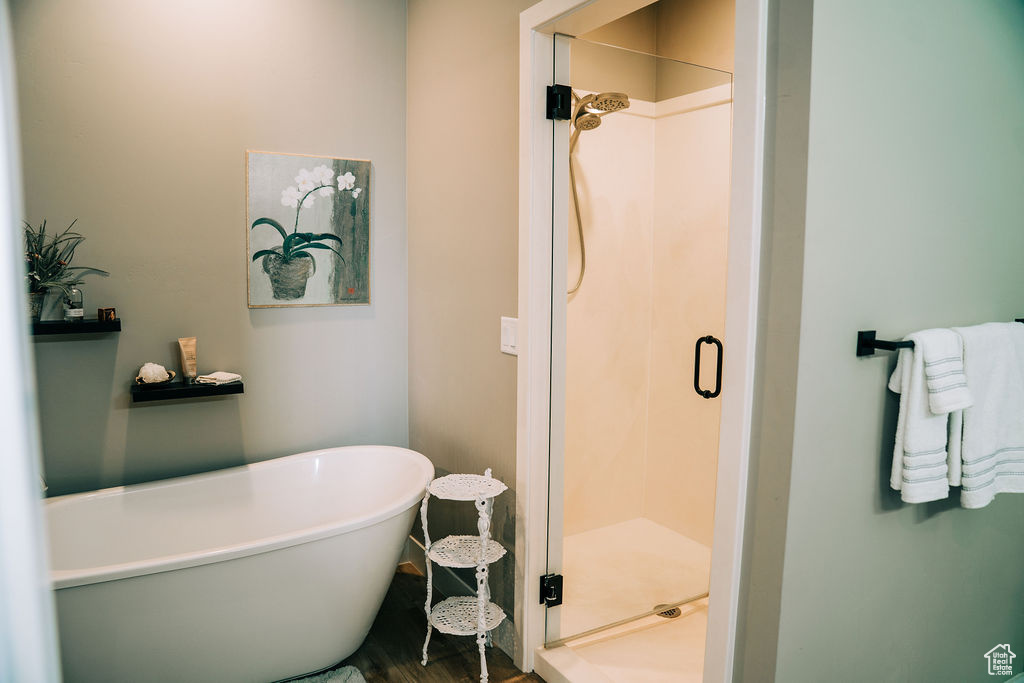 Full bathroom featuring a shower stall and a freestanding bath
