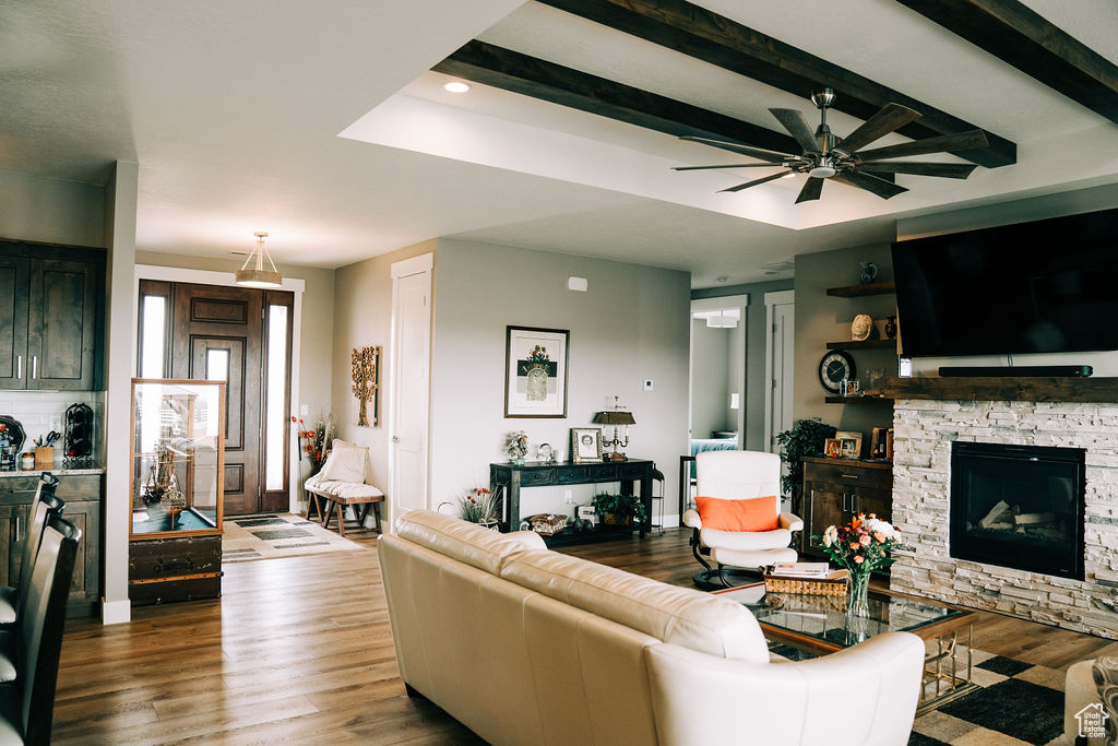 Living area featuring wood finished floors, a ceiling fan, a fireplace, recessed lighting, and baseboards