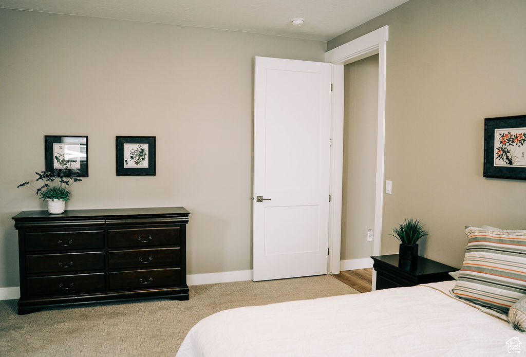 Bedroom featuring light carpet and baseboards