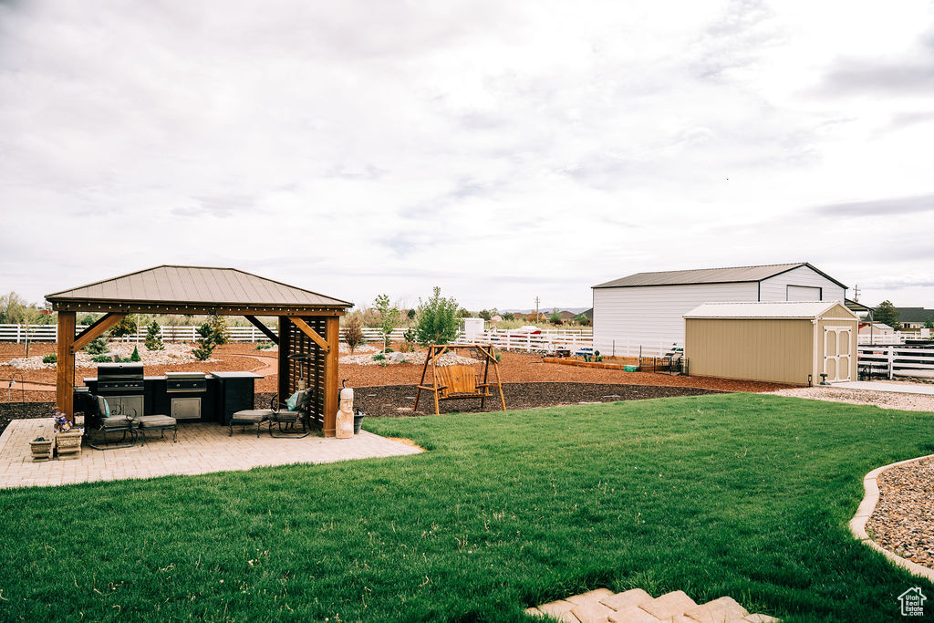 View of yard featuring a storage shed, a patio area, a gazebo, and an outdoor structure