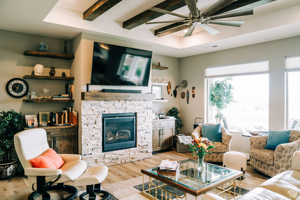 Living room with wood finished floors, a ceiling fan, and a fireplace