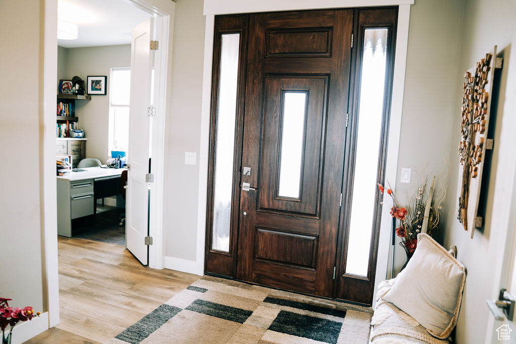 Foyer entrance with light wood-style floors and baseboards