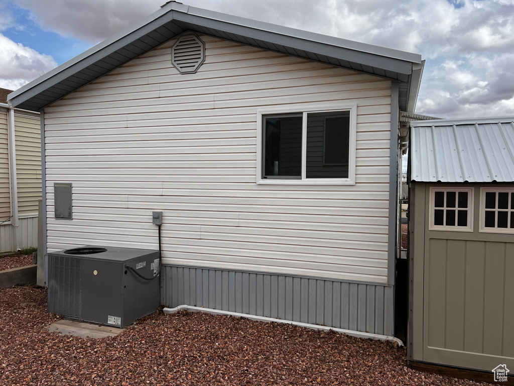 View of side of property with cooling unit