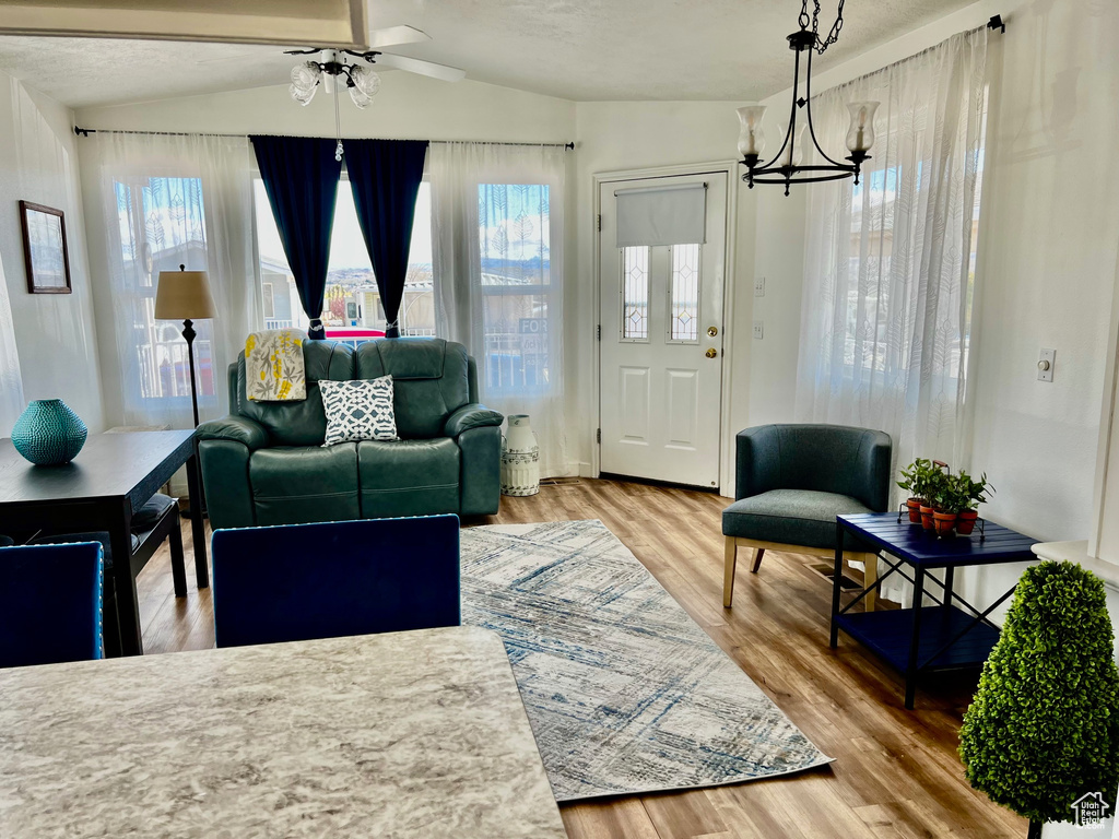 Living area with wood finished floors, a chandelier, and a ceiling fan