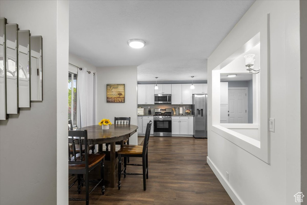 Dining area featuring dark wood-style flooring and stairway