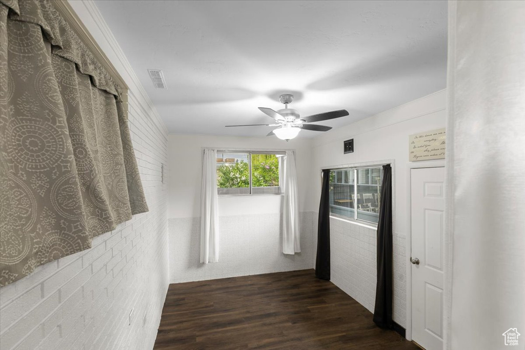 Hallway with dark wood finished floors and brick wall