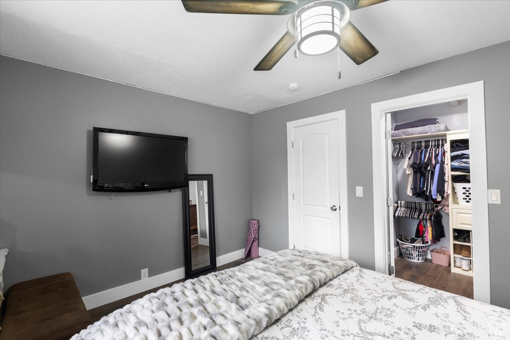 Bedroom featuring wood finished floors, a closet, baseboards, and ceiling fan