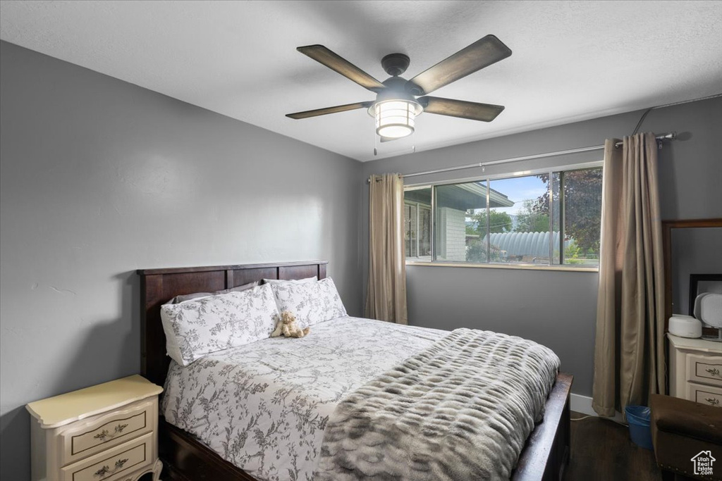 Bedroom with dark wood-style floors and ceiling fan