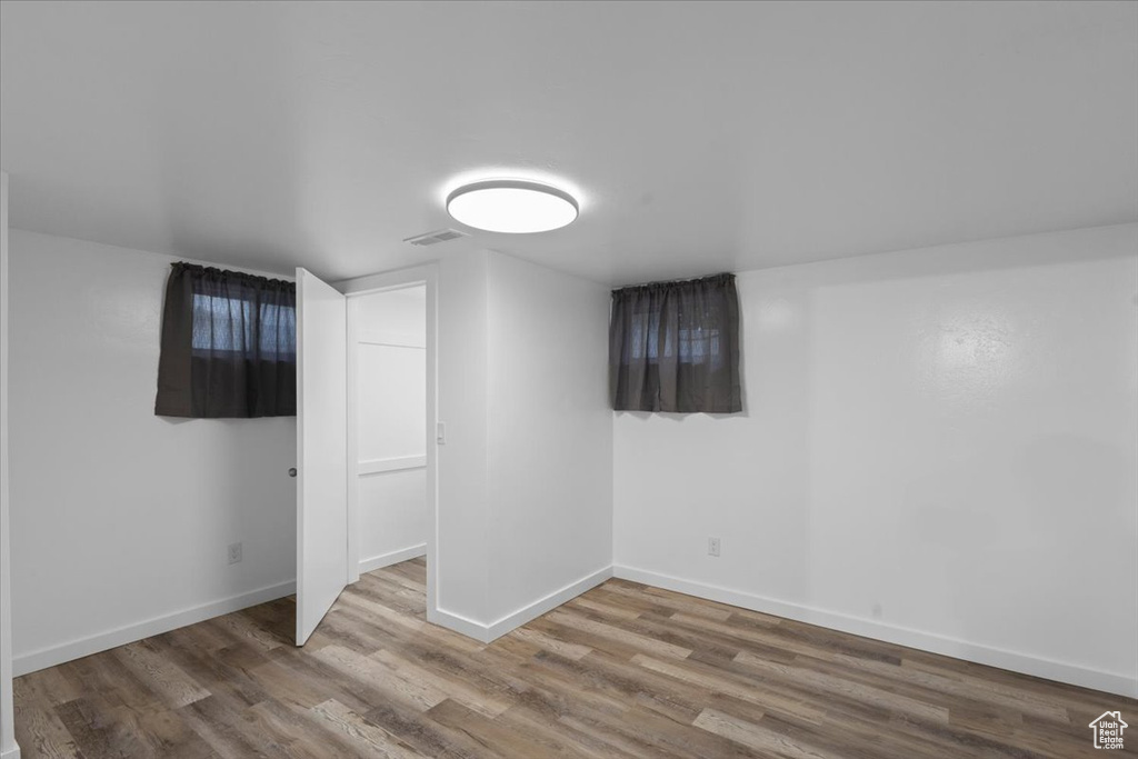 Finished basement with wood finished floors and baseboards