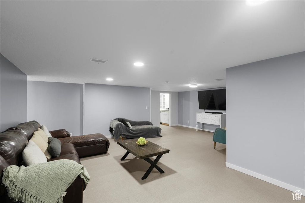 Living area featuring baseboards, light colored carpet, and recessed lighting