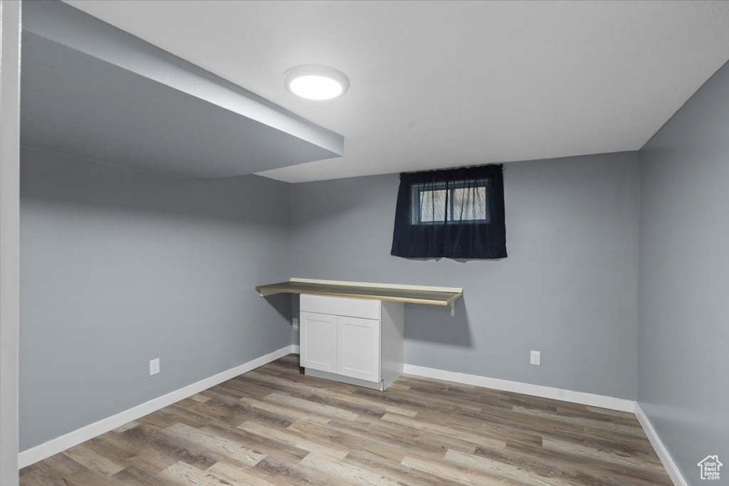 Finished below grade area featuring light wood finished floors and baseboards