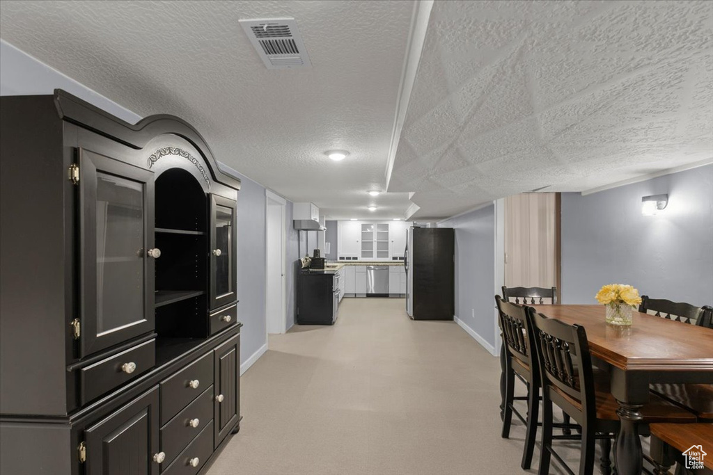 Dining room with a textured ceiling and baseboards