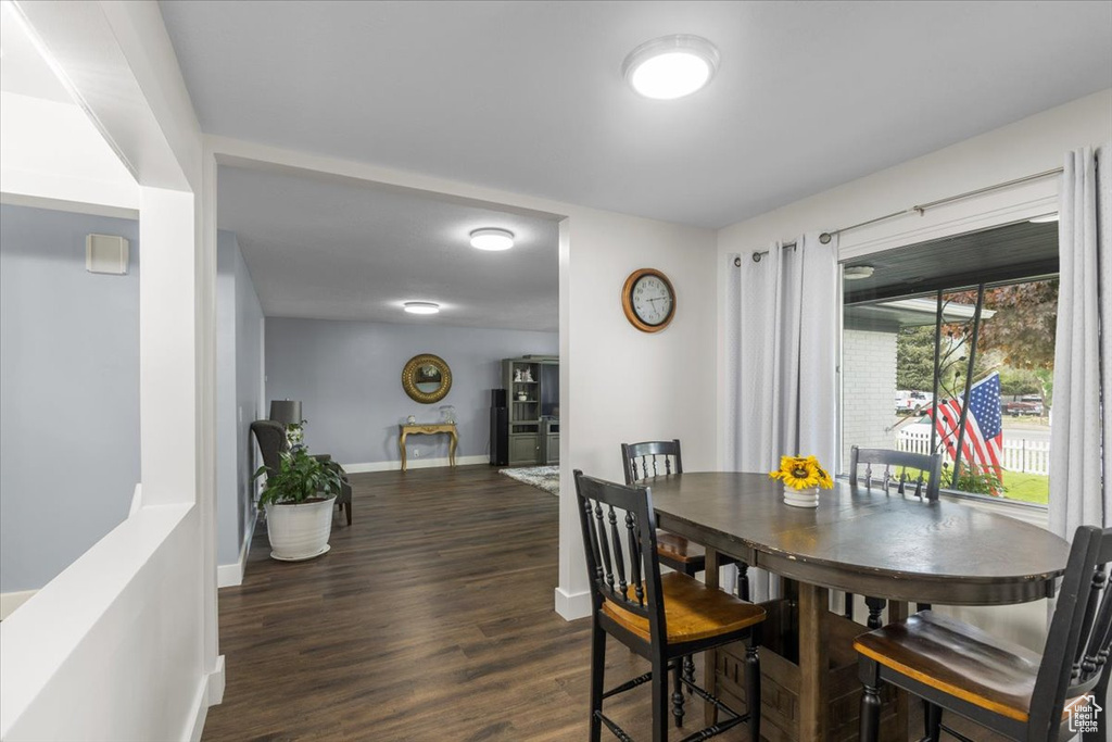 Dining space with baseboards and dark wood-style flooring