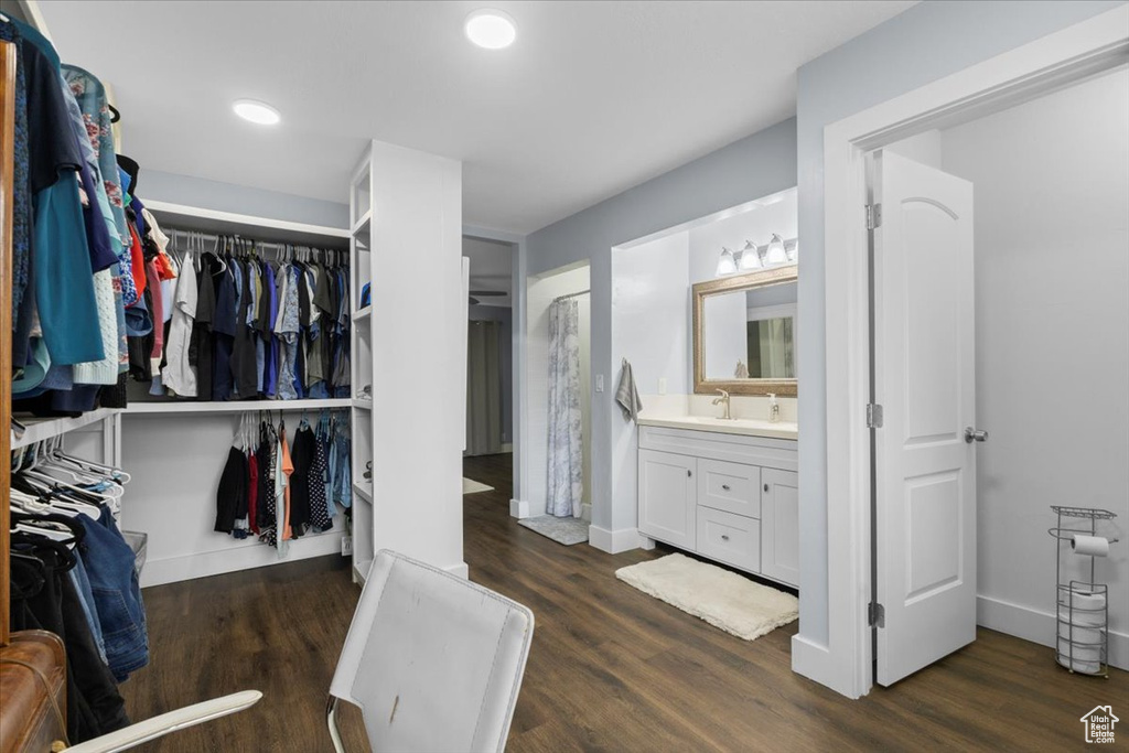 Spacious closet with dark wood-style floors and a sink