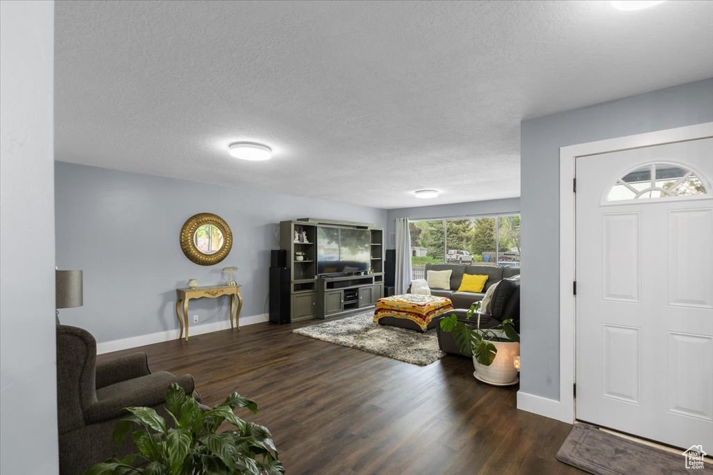Living area featuring wood finished floors, baseboards, and a textured ceiling