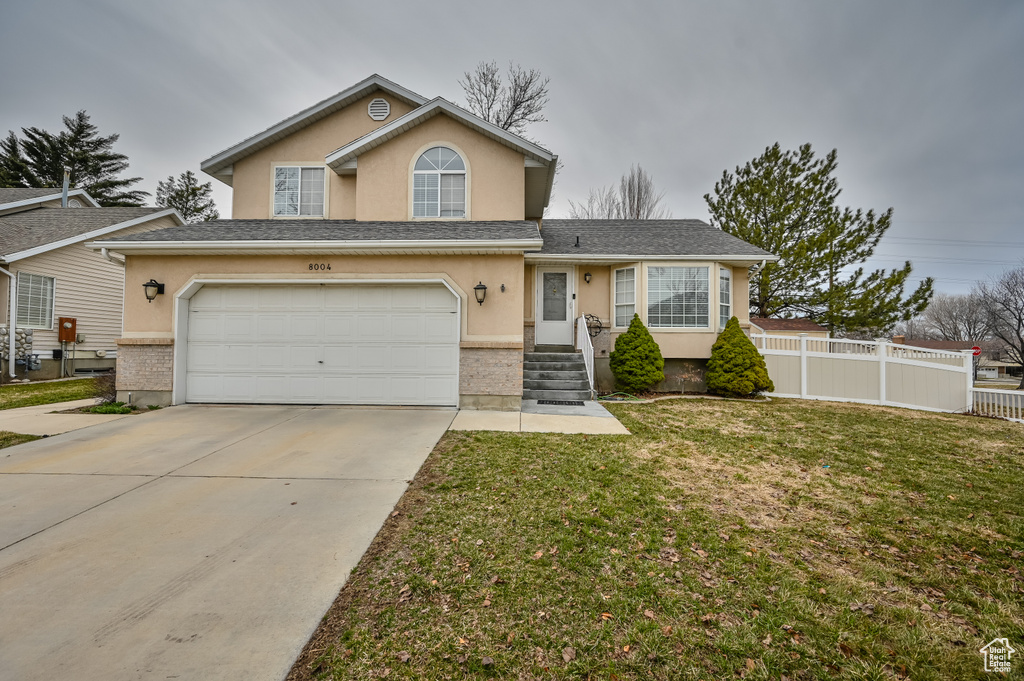 View of front of home with stucco siding, concrete driveway, and a garage