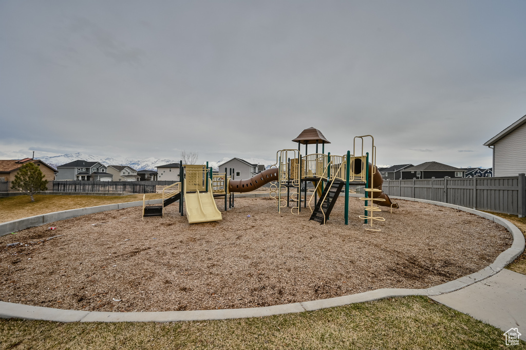 Community playground with fence and a residential view
