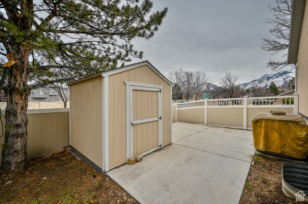 View of shed with a mountain view and a fenced backyard