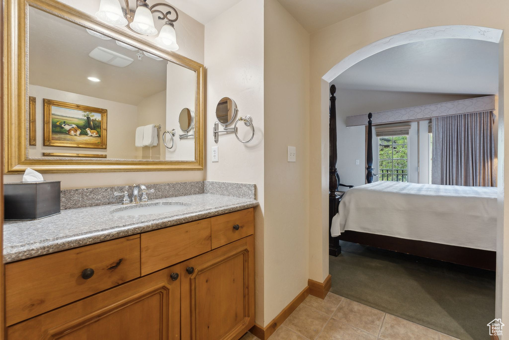 Bathroom featuring baseboards, tile patterned floors, vanity, and connected bathroom