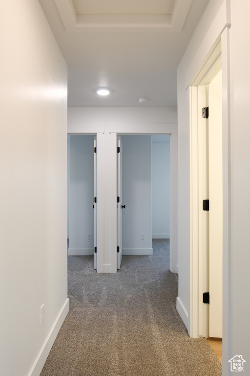 Corridor featuring carpet flooring and baseboards