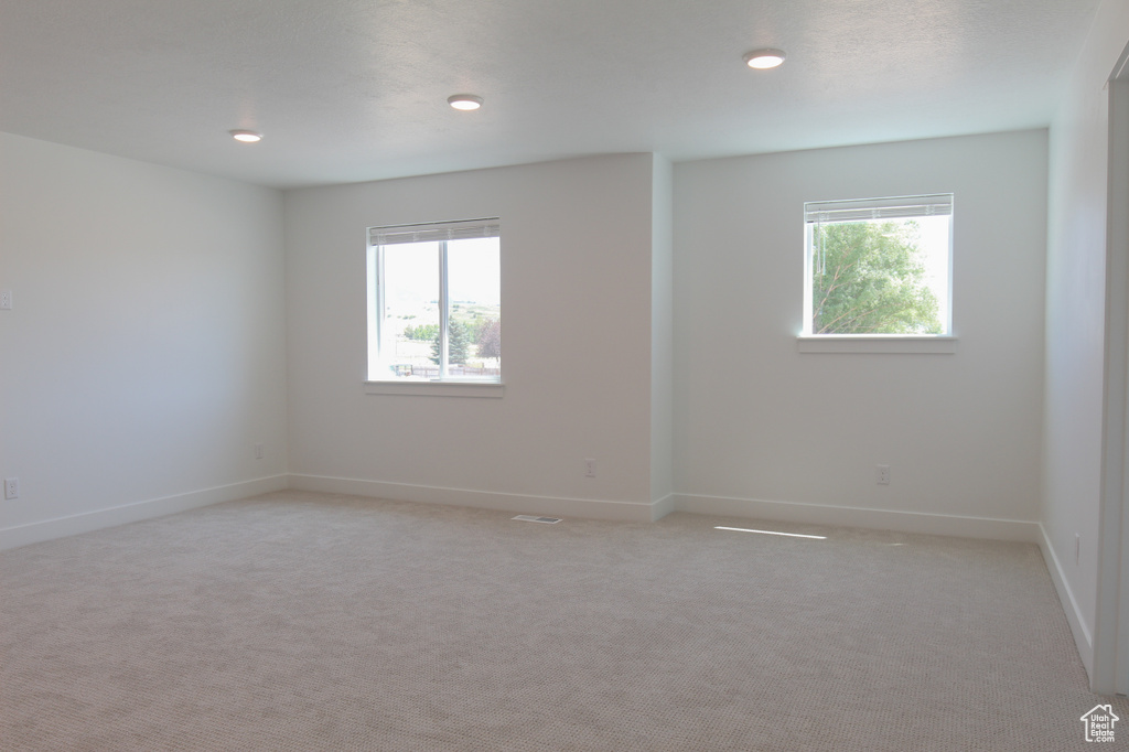 Unfurnished room with light colored carpet and recessed lighting