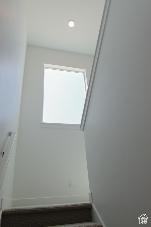 Empty room with stairs and recessed lighting