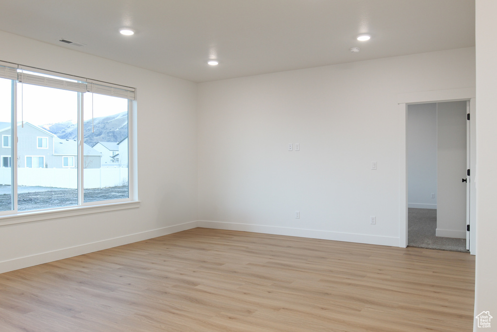 Unfurnished room featuring light wood-style floors, baseboards, and recessed lighting