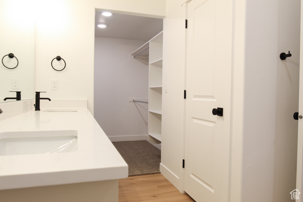 Bathroom with wood finished floors, double vanity, and recessed lighting