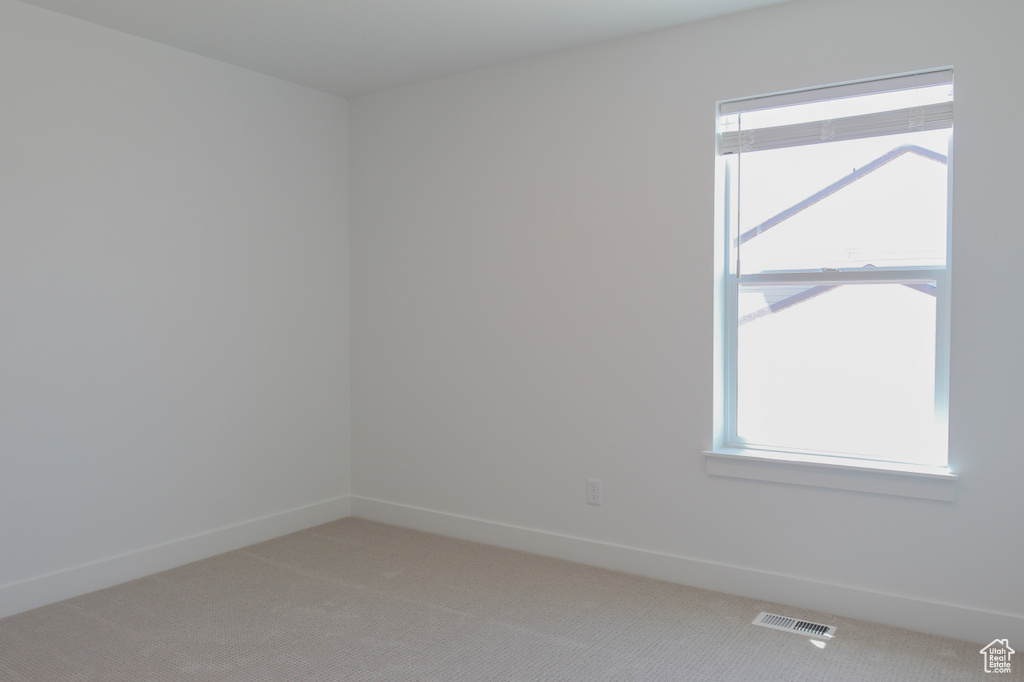 Empty room with light carpet and plenty of natural light