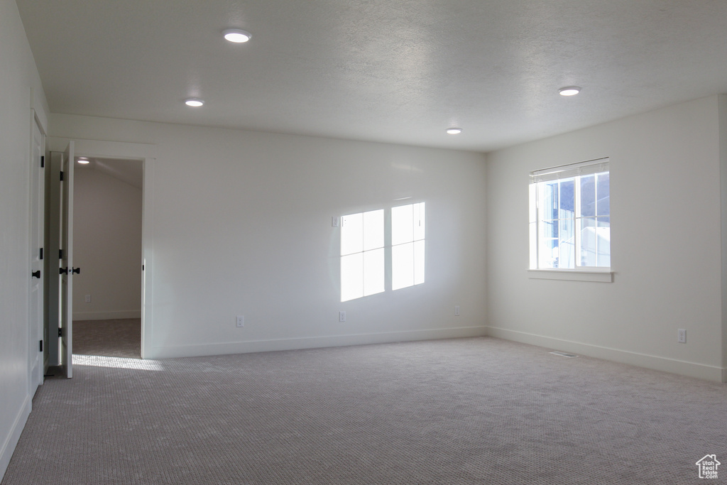 Carpeted spare room with baseboards and recessed lighting