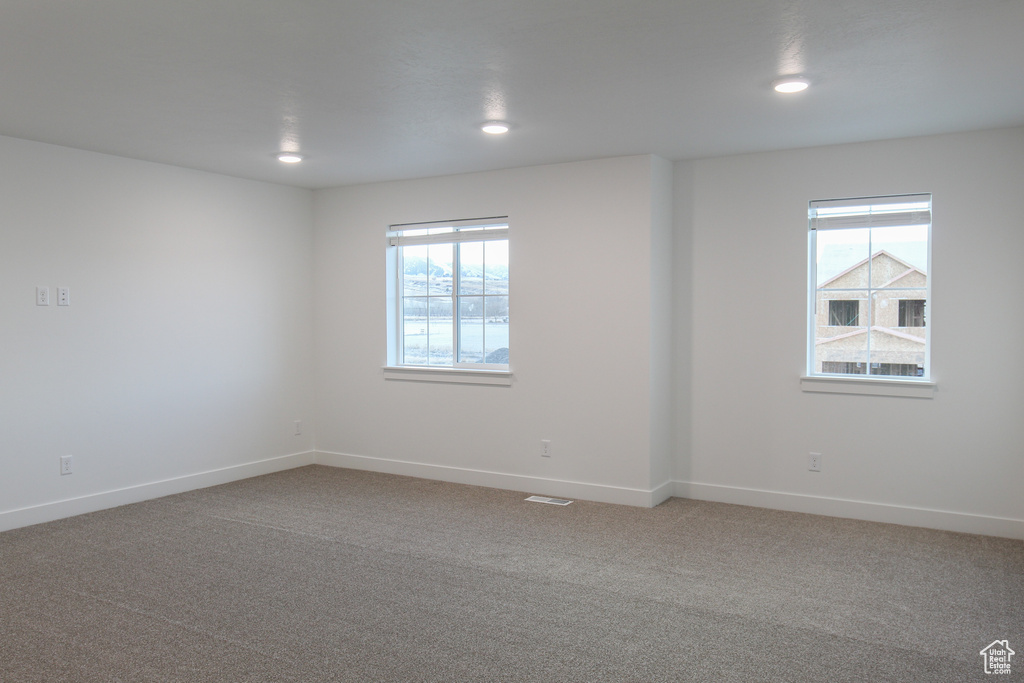 Carpeted spare room featuring healthy amount of natural light, baseboards, and recessed lighting