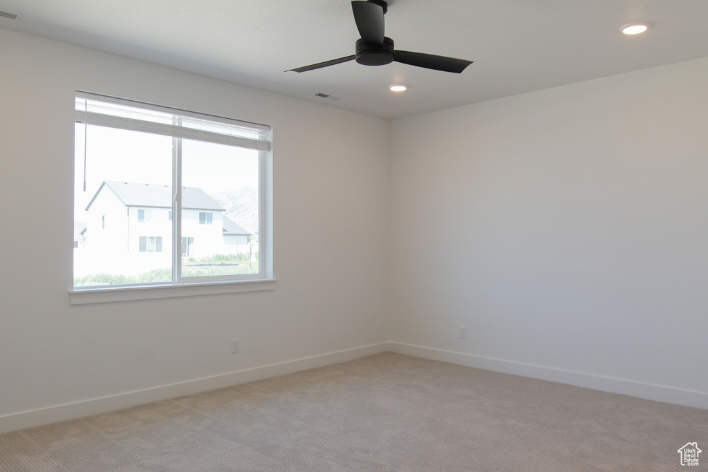 Empty room with plenty of natural light, light carpet, a ceiling fan, and recessed lighting