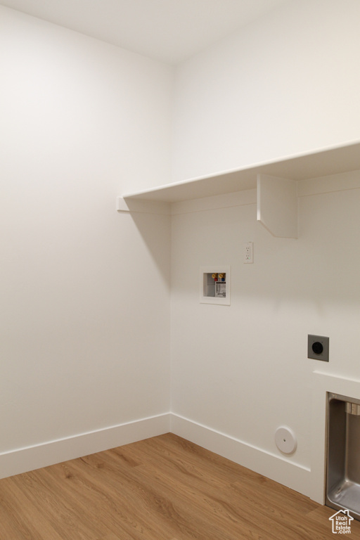 Laundry room with hookup for a washing machine, electric dryer hookup, light wood-style floors, and baseboards