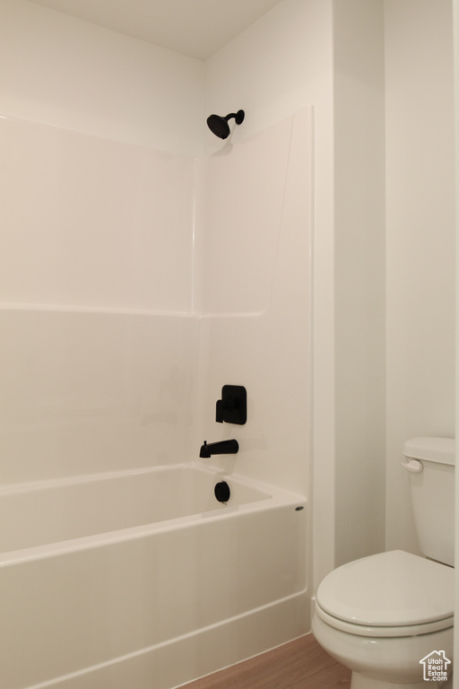 Full bath with wood finished floors and shower / bath combination