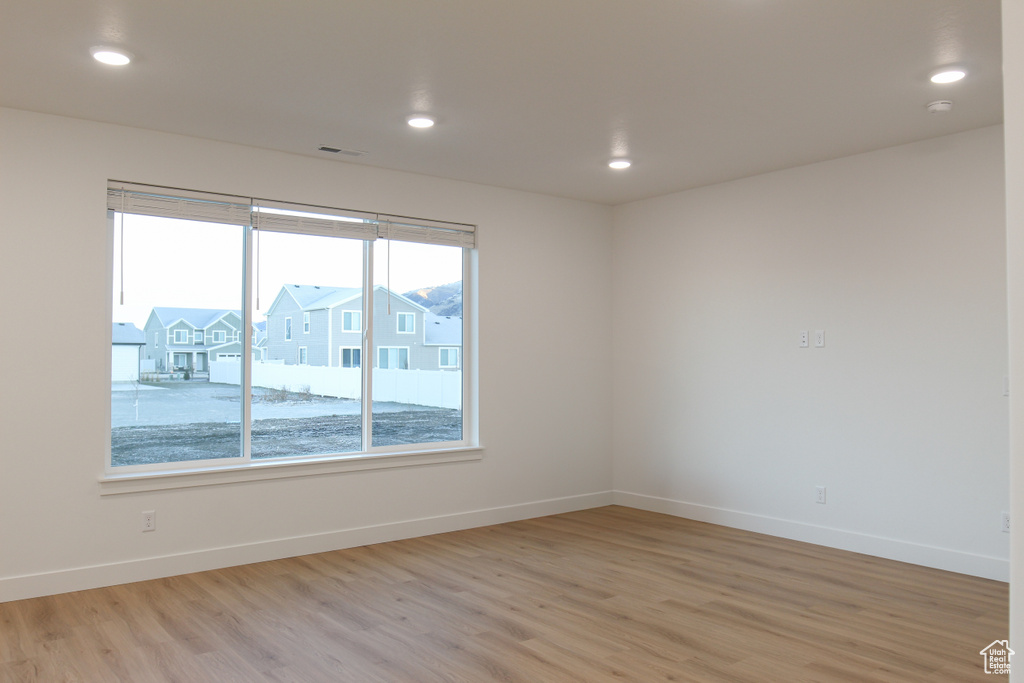 Spare room with light wood-style flooring, baseboards, and recessed lighting