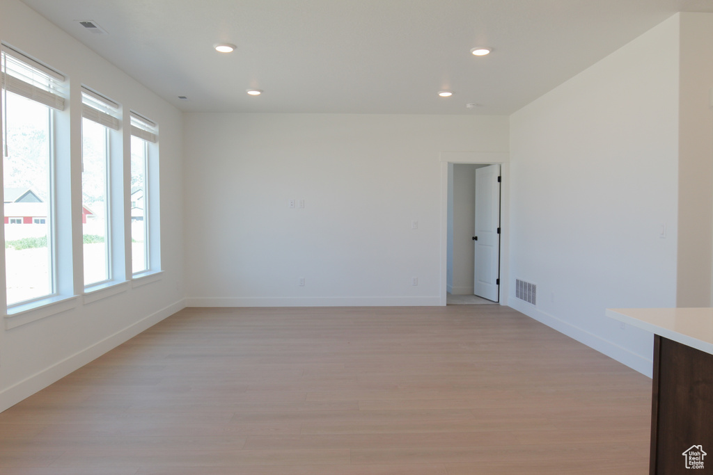 Empty room featuring light wood finished floors and recessed lighting