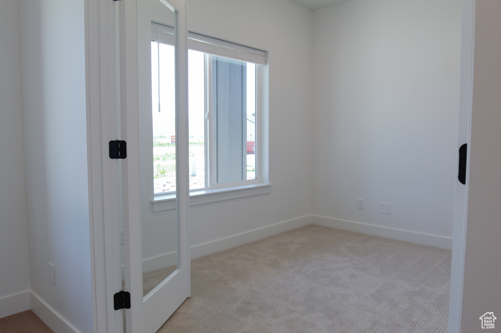 Unfurnished room with light carpet and baseboards