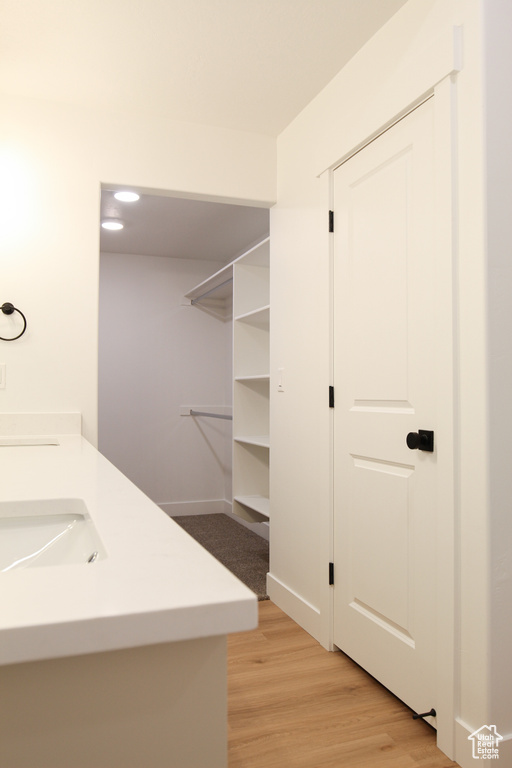 Bathroom featuring wood finished floors, baseboards, and a sink
