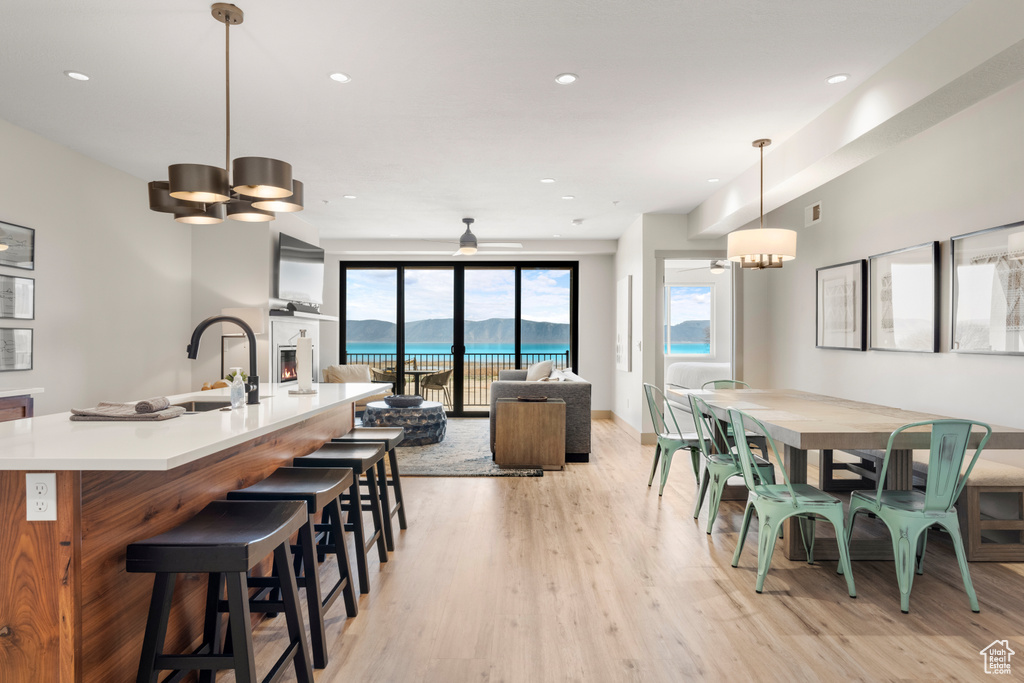 Dining room featuring light wood-type flooring, a chandelier, and recessed lighting