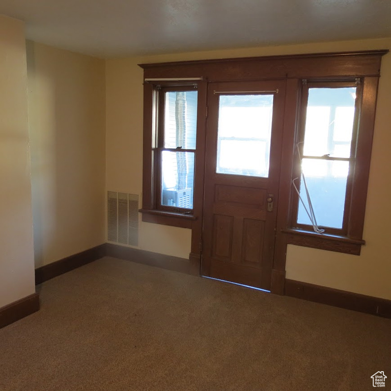 Carpeted foyer entrance featuring baseboards
