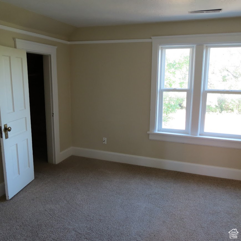 Carpeted empty room with baseboards