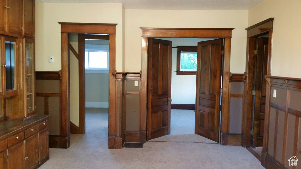 Hallway featuring light colored carpet