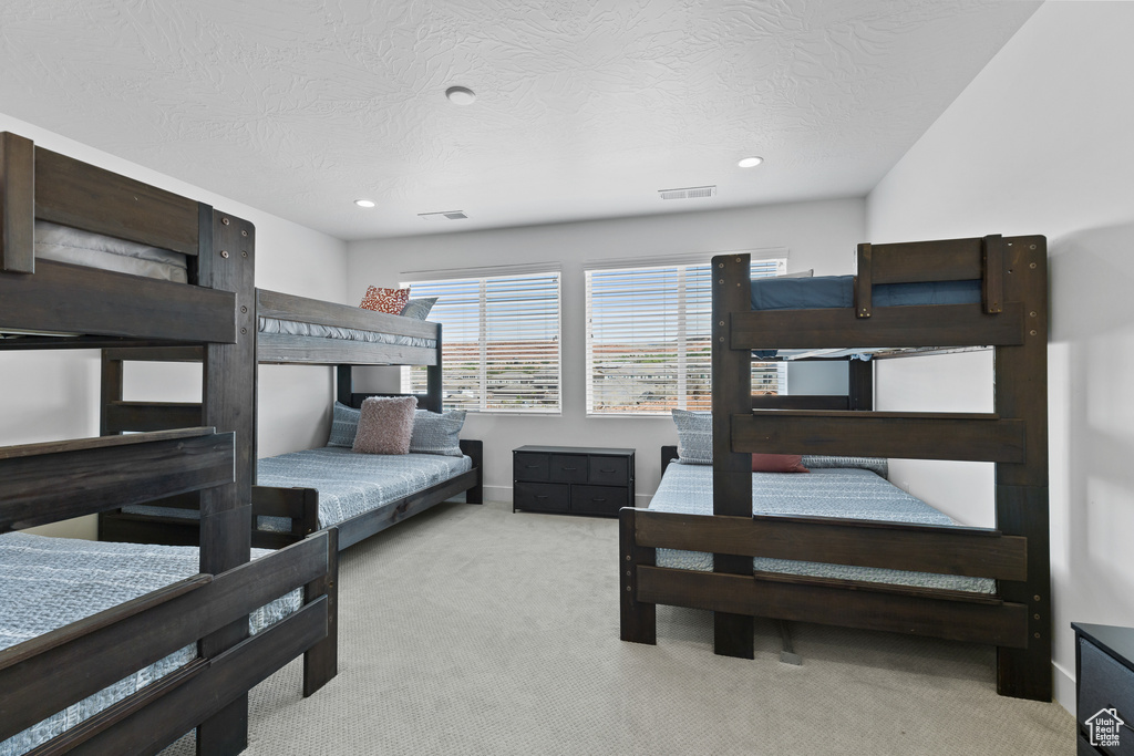 Carpeted bedroom with recessed lighting and a textured ceiling