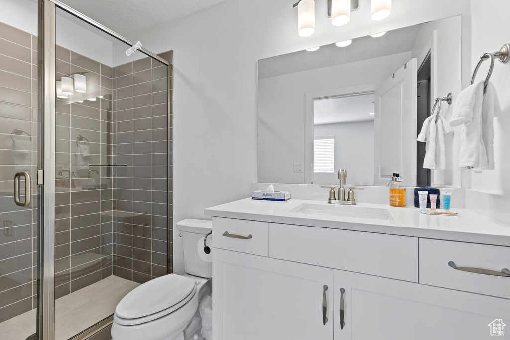 Full bath with a stall shower, toilet, and vanity