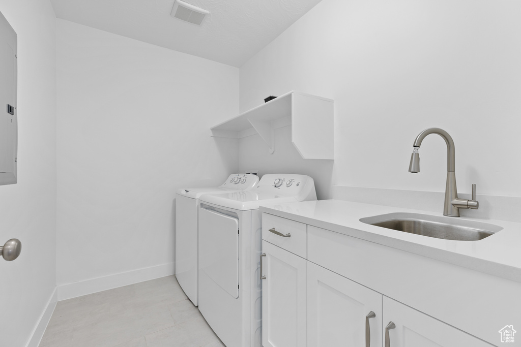Laundry room with washer and clothes dryer, cabinet space, and baseboards