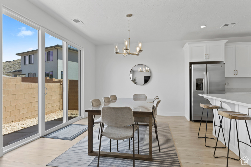 Dining space featuring light wood-style flooring, a chandelier, recessed lighting, and baseboards