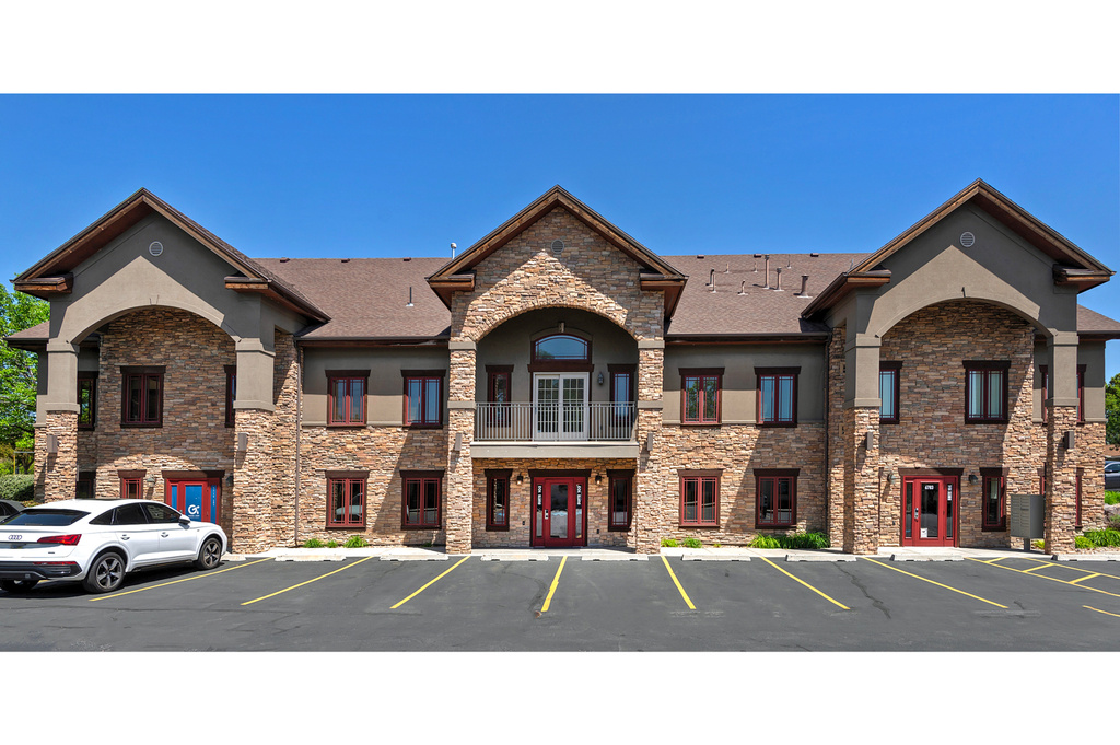 View of building exterior with uncovered parking