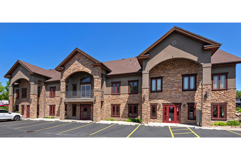 View of building exterior featuring uncovered parking